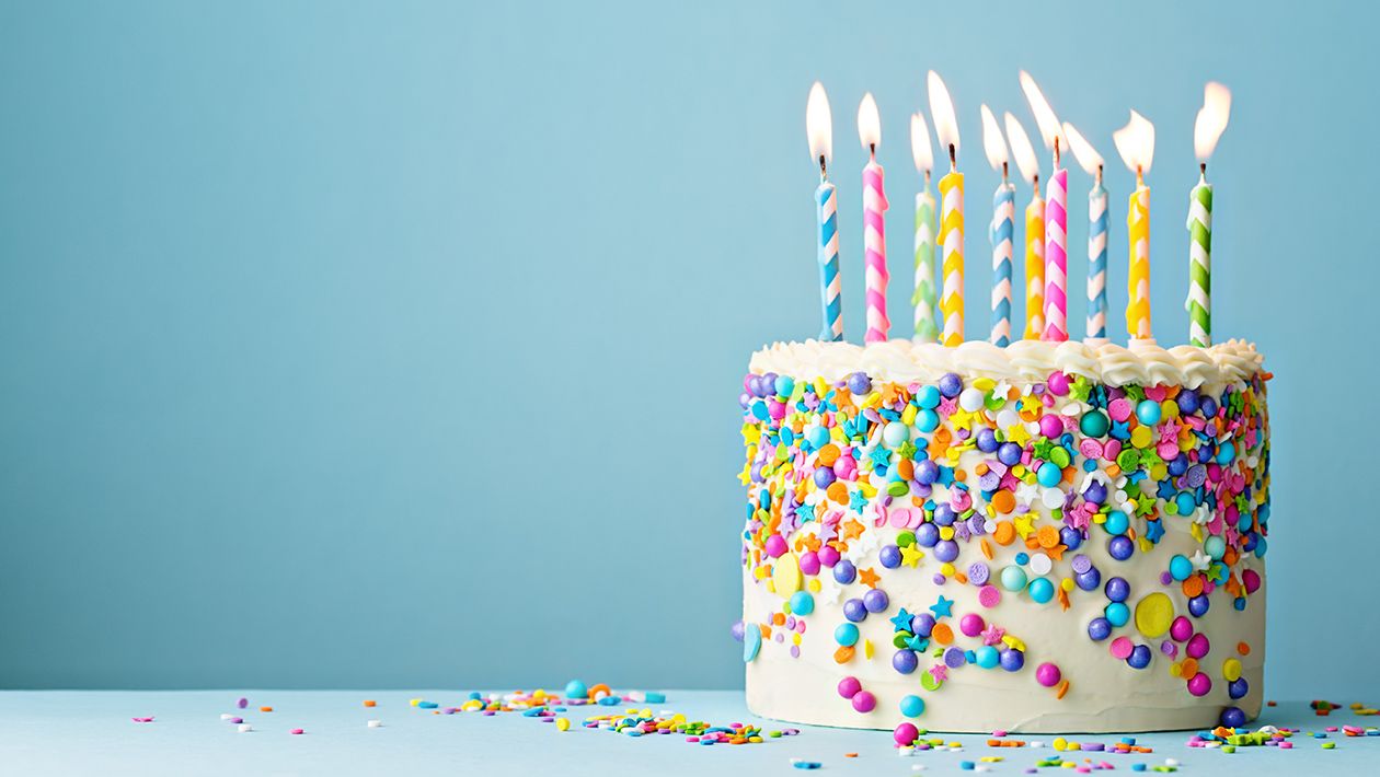 Birthday cake decorated with colorful sprinkles and ten candles